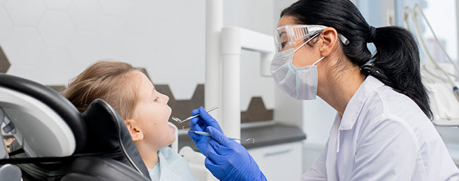 Female dentist examining child's mouth